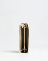 Billetera grande de cuero sintético texturizado en color blanco, con cierre perimetral dorado y logo metálico "XL" en el frente.