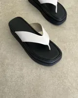 Ojota de plataforma color negro con tira ancha en forma de V de cuero vegano blanco.