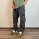 Pantalón jean cargo gris con efecto lavado, corte recto y bolsillos laterales.