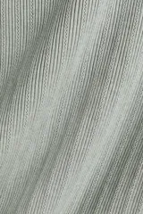 Remera de punto acanalado gris claro, de ajuste entallado con mangas raglán cortas y cuello redondo. Presenta detalles en pointelle y remates acanalados en escote, mangas y bajo.