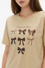Remera de algodón blanca, de corte holgado, con cuello redondo y diseño estampado en el centro que incluye un gato comiendo de un plato y la inscripción 'Wild Cats'.