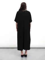 Vestido midi negro con cuello en V, mangas cortas y aberturas laterales. Confeccionado en tejido fluido con un toque de lurex.