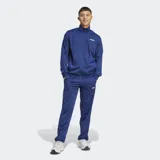 Conjunto deportivo Adidas de dos piezas, campera y pantalón, en color azul. Campera de cuello alto con cierre frontal completo y bolsillos laterales, y pantalón con cintura elástica con cordón ajustable y bolsillos laterales.