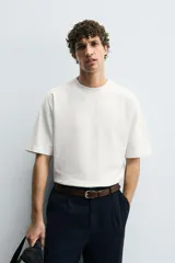 Camiseta de corte relajado confeccionada en algodón compacto, con cuello redondo y mangas cortas sin costura de sisa.