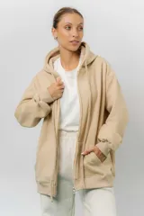 Campera deportiva con capucha de corte oversize, confeccionada en tejido suave con interior forrado en piel sintética. Presenta cierre frontal completo, bolsillos laterales y capucha amplia con cordones largos ajustables.