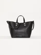 Cartera tipo tote Jazmín Chebar de cuero vacuno negro, con manijas superiores, correa regulable extraíble, acceso mediante imán y punteras metálicas decorativas.