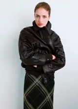 Falda midi de corte al bies con estampado de cuadros escoceses en tonos oscuros, con líneas finas en beige y naranja. Presenta un diseño fluido y ligero.