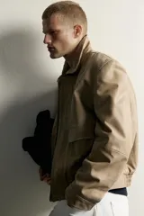 Cazadora relaxed fit de piel con efecto lavado en color tostado, cuello solapa, manga larga con puño y botones a presión. Cuenta con bolsillos plastrón con solapa en la cadera, bolsillo interior y cierre frontal con cremallera oculta por solapa con botones a presión.