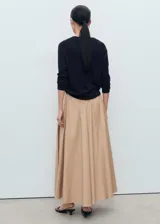 Jersey de punto fino color negro, con cuello en pico y manga larga. Presenta un diseño recto y minimalista.