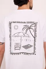 Camiseta blanca de manga corta con estampa en la espalda de una escena de playa enmarcada.