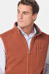 Chaleco deportivo rojo de polar con forro e interior en color azul combinado, cierre frontal y bolsillos delanteros con cierre metálico personalizado. Incluye dos bolsillos interiores con cierre y logo bordado en el pecho.