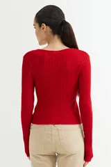 Sweater negro de tejido de punto acanalado, con escote en V y cierre frontal con cremallera circular.