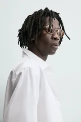 Camisa de manga larga, color blanco, con cuello italiano y corte slim fit. Presenta cierre frontal de botonadura y puños con botón.