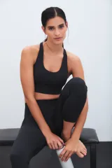 Top deportivo negro de escote redondo y espalda estilo nadadora, con banda elástica inferior para mayor soporte.
