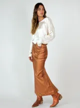 Falda midi color cobre metalizado, de corte ajustado y con tajo trasero.