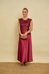 Pollera midi de satén color bordó, cortada al bies, con silueta evasé fluida y elegante.