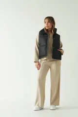 Chaleco puffer negro con cuello alto y bolsillos laterales.