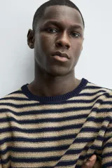 Jersey de punto con diseño de rayas horizontales en azul marino y beige, de corte regular fit. Presenta cuello redondo, manga larga y acabados en rib en cuello, puños y cintura. Confeccionado en tejido de algodón.