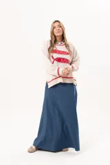 Sweater tejido color crudo con cuello redondo y mangas largas. Presenta dos peces rojos con detalles en azul bordados en el frente. Tiene ribete ondulado rojo en cuello, puños y ruedo.