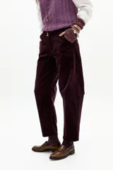 Pantalón de corduroy color berenjena, de corte barrel relajado, tiro medio, cierre frontal, bolsillos laterales y amplios bolsillos traseros.