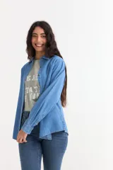 Camisa de jean de manga larga con cuello clásico y cierre frontal de botones. Confeccionada en tejido de algodón, presenta un corte recto y puños abotonados.