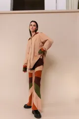 Pantalón acampanado de pana color beige con parches de pana marrón, verde y naranja.