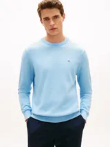 Sweater de punto celeste de cuello redondo, de manga larga con puños y bajo de canalé, confeccionado por Tommy Hilfiger en puro algodón con un pequeño logo bordado en el pecho.