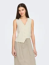 Chaleco sastrero color beige claro, de corte entallado, con escote en V y cierre frontal de botones. Presenta bolsillos falsos con pespunte en la parte inferior delantera.