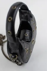 Cartera mini hobo estructurada de cuero negro, decorada con arandelas metálicas doradas en toda la superficie. Cuenta con asa corta de mano y correa de cadena metálica extraíble.
