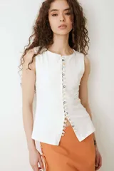 Musculosa turquesa de algodón con escote redondo y cierre frontal decorado con una hilera de múltiples botones vintage variados.