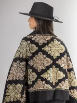 Pashmina color bordó con bordados florales en hilo dorado y bronce, terminada con flecos en los extremos.