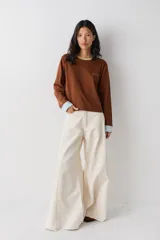 Remera de manga larga color marrón con cuello redondo en tono verde claro y puños en tono celeste. Presenta el logo de la marca bordado en el pecho.