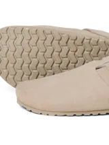 Zueco tipo mule de gamuza color taupe, con puntera redonda, tira ajustable con velcro y suela de corcho con base de goma.