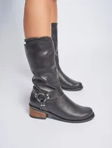 Bota de caña media de cuero negro, con taco de madera y detalle de aro metálico en el tobillo.