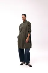 Vestido camisero de silueta amplia y fluida, color verde militar, con cuello camisero, frente abotonado parcial, mangas largas y bolsillos laterales.