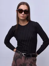 Top de punto negro con diseño de rayas verticales en relieve y cuello redondo. Presenta un corte ajustado con costuras decorativas que definen la silueta y mangas largas.