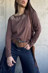 Remera de manga larga color chocolate, con cuello redondo y diseño bordado en hilo blanco alrededor del escote.