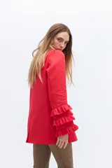 Blazer color beige confeccionado en lino, con cuello solapa, cierre frontal con un botón y mangas largas con volantes en capas.