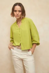 Camisa verde lima de manga larga con cuello mao y escote en V. Cuenta con botones forrados en la misma tela y puños elásticos.