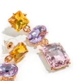 Aros colgantes con base dorada y tres gemas de diferentes colores y formas: cuadrada amarilla, ovalada lila y rectangular rosa.