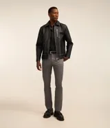 Pantalón slim de sarga color gris, con bolsillos laterales tipo cuchillo y cierre frontal con botón y cremallera.