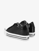 Zapatillas negras con lentejuelas, caña baja, cordones negros y plataforma blanca con rayas horizontales negras.