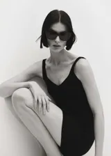 Top sin mangas de tejido de punto acanalado, con escote en pico tanto en el frente como en la espalda y diseño entallado al cuerpo.