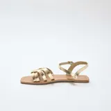 Sandalias planas color dorado, con múltiples tiras delanteras cruzadas y tira ajustable al tobillo con hebilla metálica.
