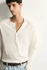 Remera polo de manga larga y calce regular fit en color blanco off-white, confeccionada en mezcla de algodón y lino, con cuello redondo y cartera con botonadura frontal.