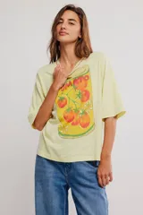 Remera oversize de algodón color amarillo claro, con escote redondo, mangas cortas amplias y hombros caídos. Cuenta con estampa ilustrada al frente de una lata de tomates.