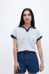 Remera blanca con rayas horizontales finas en azul marino, escote en V con cuello tipo polo y mangas cortas con terminación en puño azul marino.