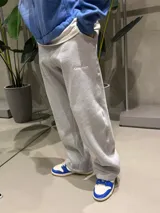 Pantalón de jogging gris melange de corte holgado y estilo urbano, con bordado pequeño en la parte superior delantera y cintura elástica.