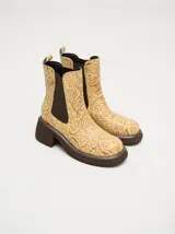 Bota tipo Chelsea de caña media, confeccionada en cuero vacuno negro con acabado mate. Presenta paneles laterales elásticos, tirador trasero y una suela robusta con plataforma delantera y taco cuadrado.