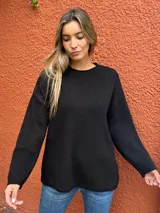 Sweater de tejido de punto color negro, con cuello redondo, mangas largas y corte holgado.